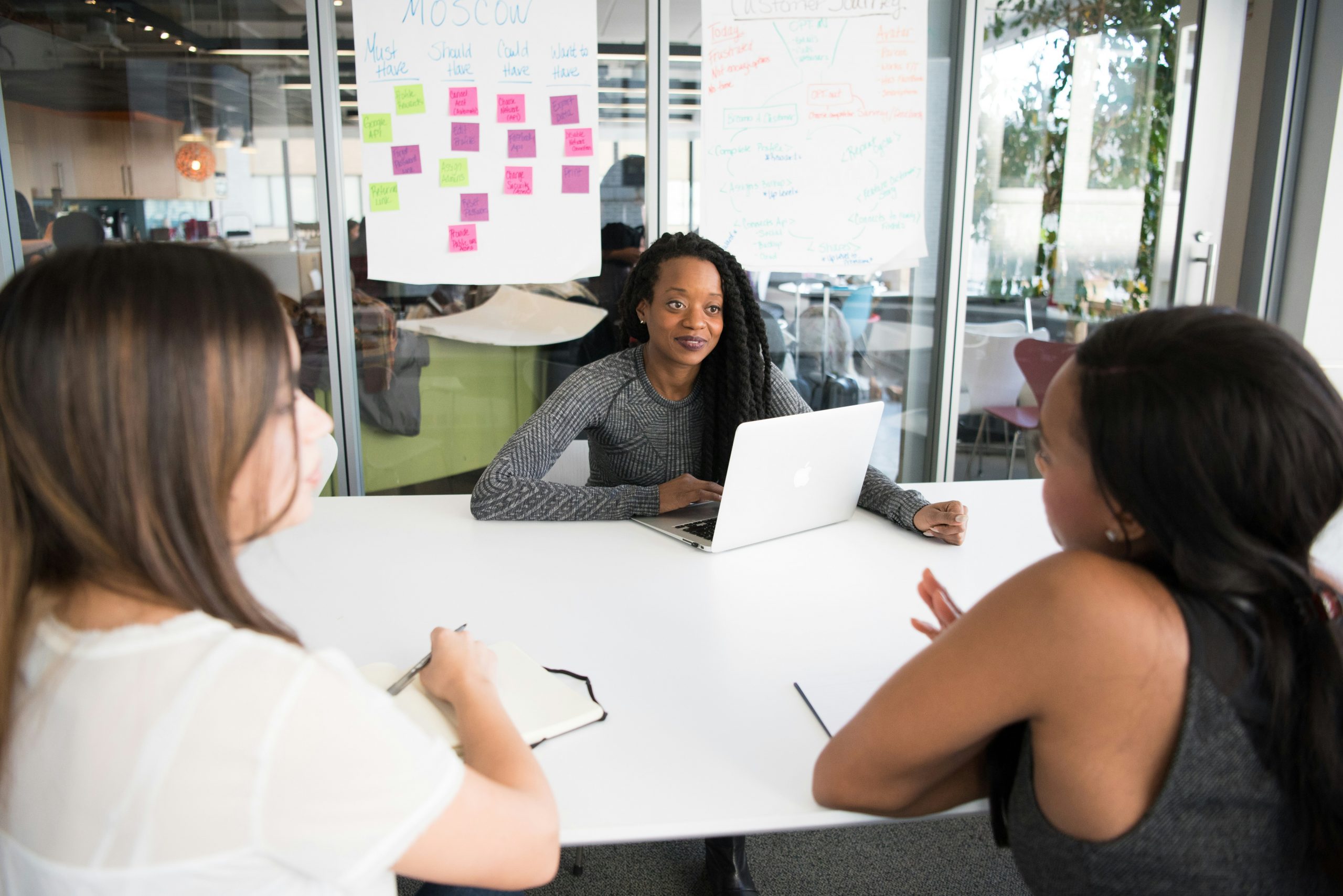 three professional Black women around a table in an office